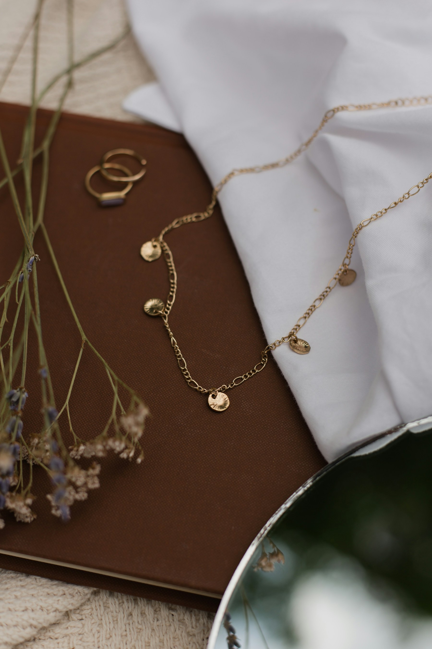 Colar dourado Harmoniê em composição com flores